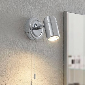 Moderne Lindby Remilan Bad-Wandleuchte aus Chrom-Metall mit Zugschalter, IP44 spritzwassergeschützt, leuchtet warm.
