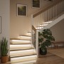 Paulmann MaxLED Stair LED-Strips beleuchten eine moderne Holztreppe mit warmem Licht im Flur. Stilvolle Treppenbeleuchtung.