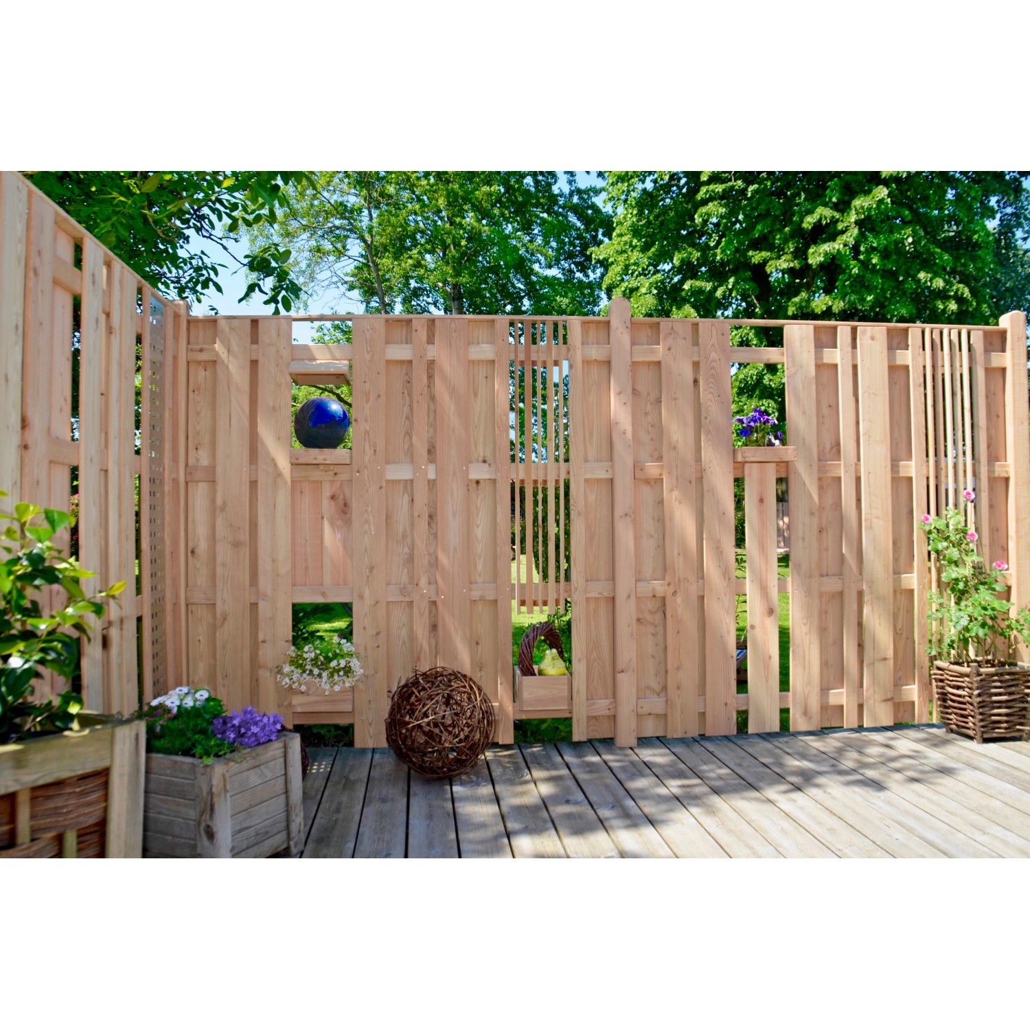 T & J Sichtschutzzaun Aalborg aus Lärche, 180x180 cm, naturbelassen, mit dekorativen Elementen im Garten.