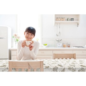 d-c-fix Tischbelag Meadowia Sepia, 140 cm, mit Frau und Kaffeetasse in Küche.