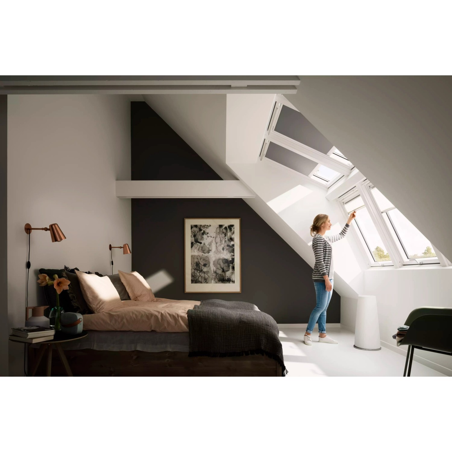 Frau bedient Velux Verdunkelungsrollo Grau-Weiß im Dachfenster für optimale Verdunkelung.