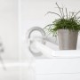 Ecopots Amsterdam Mini Pflanztopf in Taupe mit grüner Pflanze auf weißem Tisch.