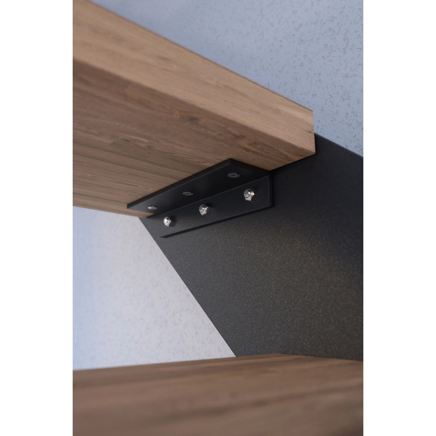 Detailaufnahme: Buchenholz-Stufe der Treppe Kos mit anthrazitfarbenem Metallgeländer.