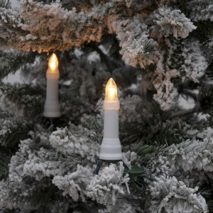Konstsmide LED Baumkette mit bernsteinfarbenen Dioden am verschneiten Weihnachtsbaum.