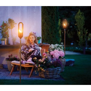 Gardena Fackel ClickUp! im Garten mit Frau. Stimmungsvolle Gartendekoration.