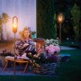Gardena Fackel ClickUp! im Garten mit Frau. Stimmungsvolle Gartendekoration.