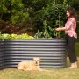 Westmann Metall Hochbeet Grow Faster in Anthrazit mit Frau beim Bepflanzen und Hund im Garten.