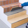 Fliesenleger verlegt Fliesen mit Knauf Flexkleber Schnell Grau auf einer Treppe.