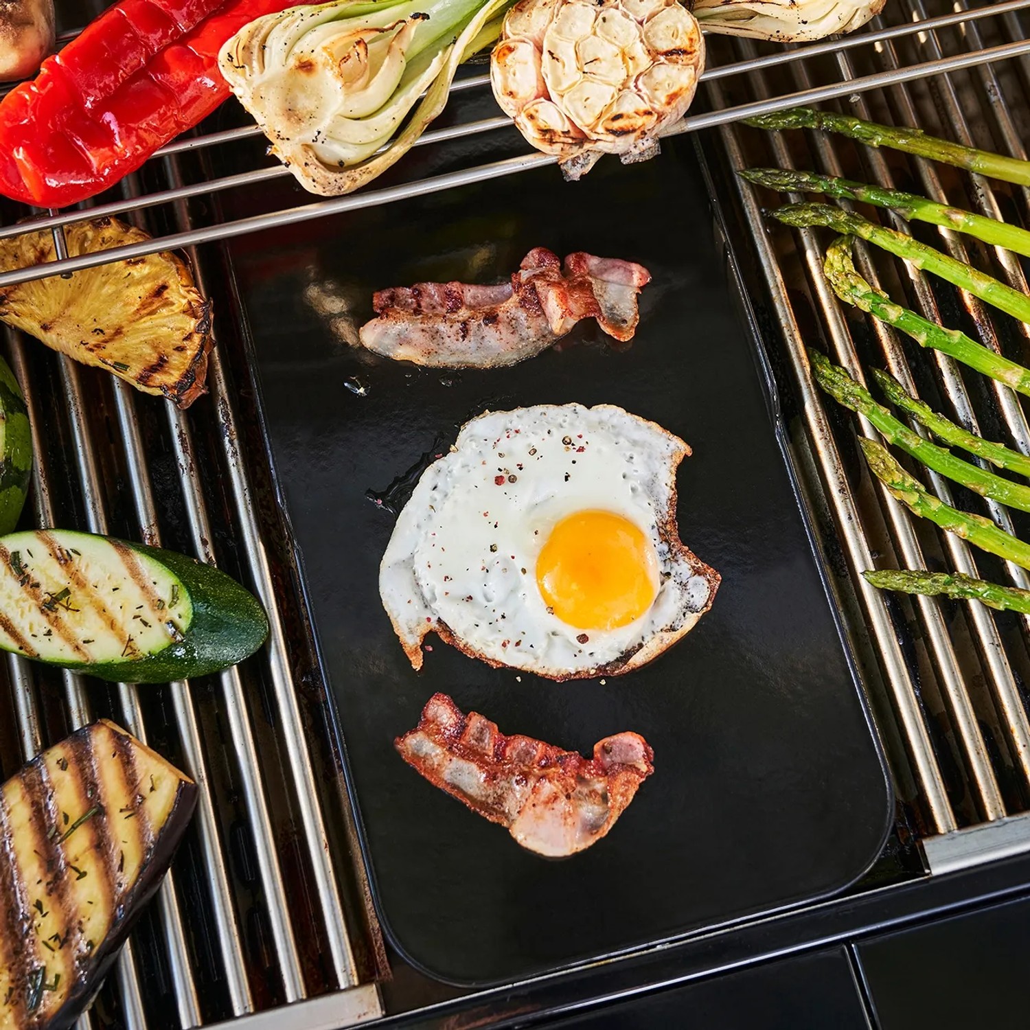 Char-Broil Grillplatte Smart-E mit Spiegelei und Bacon auf Grill mit Gemüse.