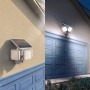 Philips Zyren Solar-LED-Außenstrahler mit Bewegungsmelder, tagsüber und nachts an Hauswand montiert.