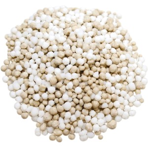 Nahaufnahme von OBI Premium Langzeit-Rasendünger, weiße und beige Düngerkügelchen.