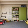 Innenansicht Palmako Ella Holz-Gartenhaus (610x300cm) mit Gartengeräten und Regalen.
