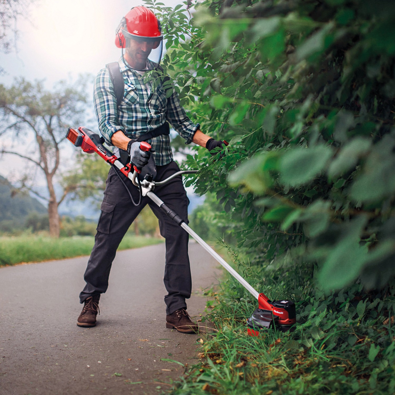 Einhell Akku-Sense Agillo: Akku-Trimmer im Einsatz mit Schutzkleidung für Gartenarbeiten.