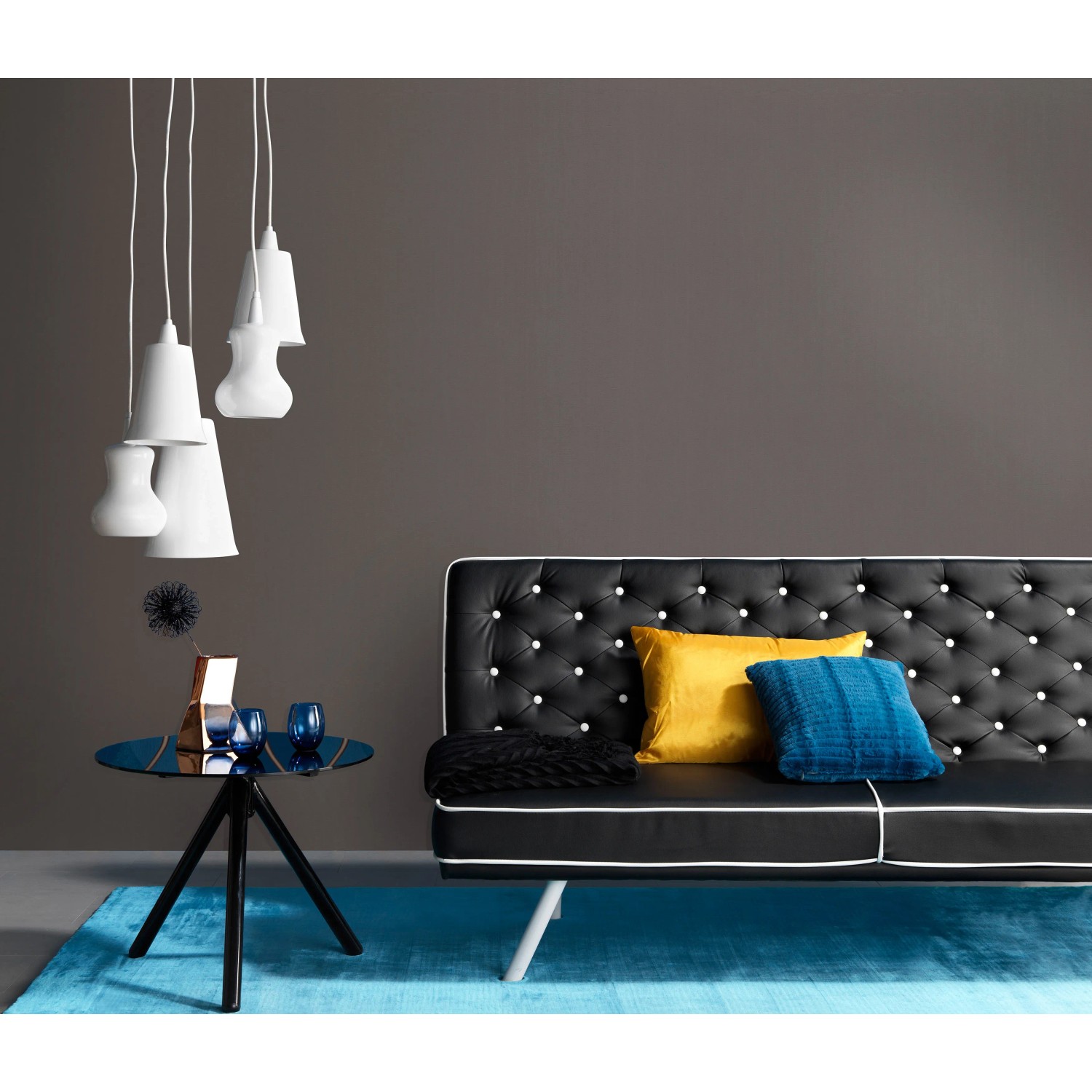 Wohnraum mit schwarzer Erismann Vliestapete Spotlight Uni, Sofa und Tisch.