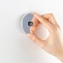Hand befestigt Wenko Vacuum-Loc® Seifenspender Quadro aus Edelstahl an weißer Wand.