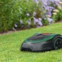 Bosch Indego S 500 Mähroboter auf Rasen, mit Blumen im Hintergrund.
