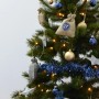 Adventskalender-Säckchen aus Jute-Stoff am Weihnachtsbaum, dekoriert mit Lichtern, Kugeln und Sternen.