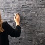 Egger DecoWall Wandpaneel Narva Schiefer, graue Steinoptik, mit Hand berührt.