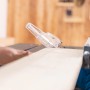 Scheppach HS210 Tischkreissäge beim Sägen eines Holzbretts.