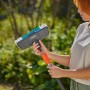 Gardena Cleansystem Stielbürste Hard in Anthrazit mit Frau im Garten. Ideal zur Nassreinigung.