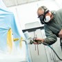 Lackierer mit Dräger Halbmaske X-plore 3300 Lackiererset beim Lackieren eines Objekts.