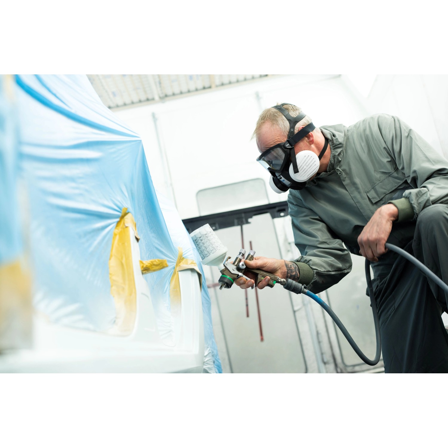 Lackierer mit Dräger Halbmaske X-plore 3300 Lackiererset beim Lackieren eines Objekts.