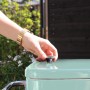Mintfarbener Axi Kühlwagen Retro (76 l) mit Hand am Deckelverschluss.