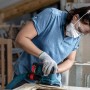 Frau schleift Holzrahmen mit Bosch Expert Schwingschleifer und Schleifblatt C470.