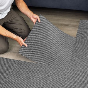 Verlegen von grauen Floordirekt Teppichfliesen Bern 50x50 cm mit Streifenmuster.