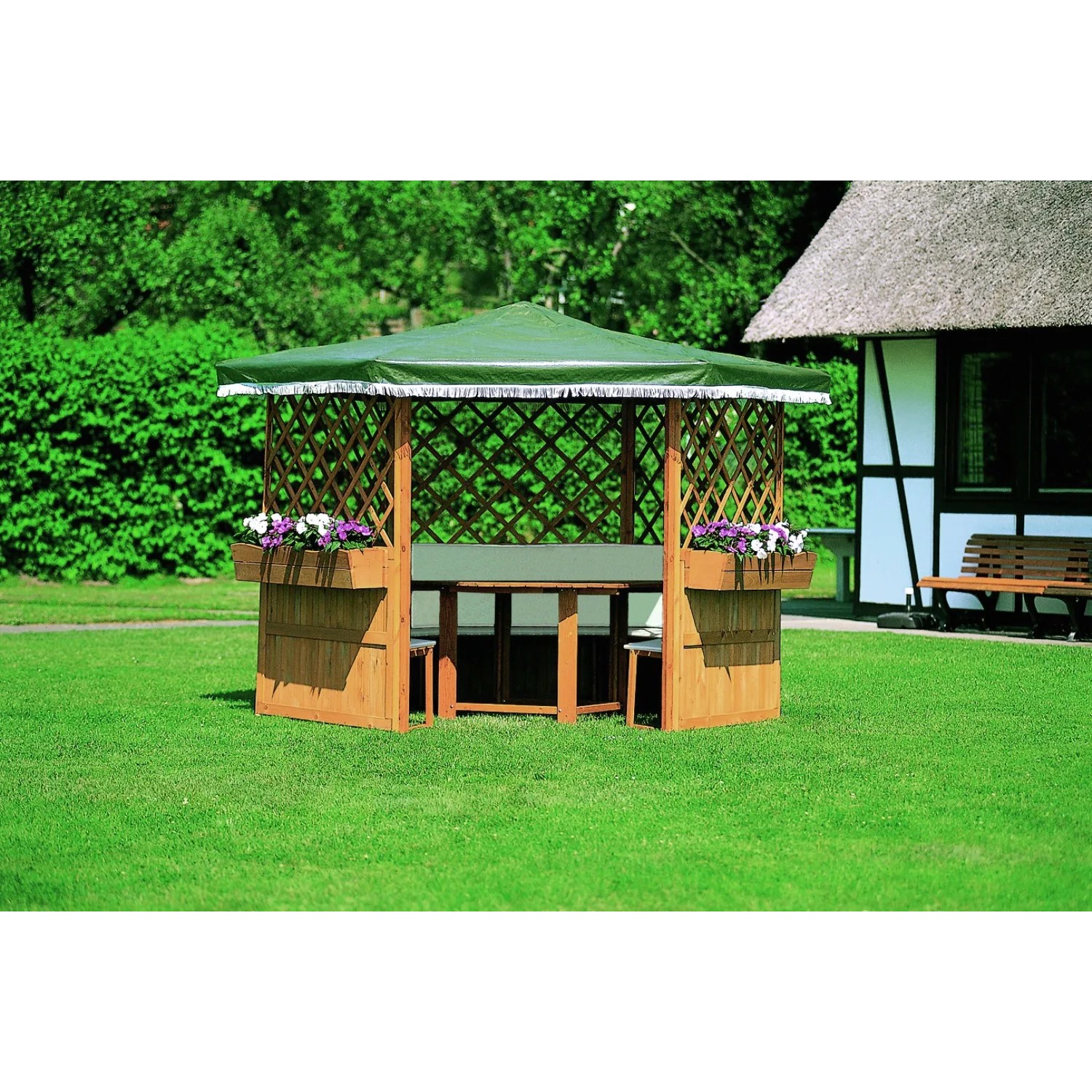Pavillon Marburg mit Möbeln: Holzpavillon mit Tisch, Bänken und grünem Dach im Garten.