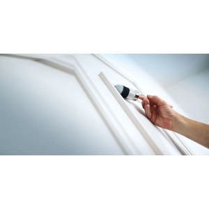 Hand streicht weiße Tür mit LUX Ringpinsel Expert 25 mm. Pinsel für Lacke und Farben.