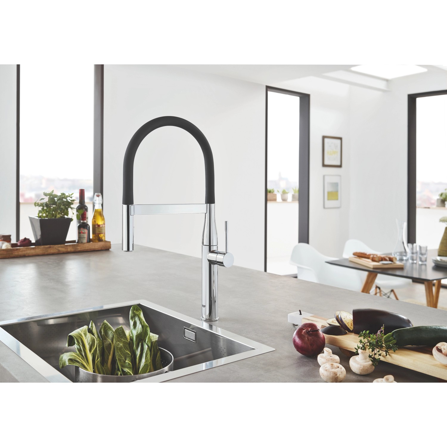 Grohe Essence Küchenarmatur in Chrom mit schwarzem, flexiblem Auslauf vor Küchenspüle.