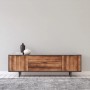 Helle, unifarbene Wand als Hintergrund für ein Holz-Sideboard mit Deko-Vasen. Dekorative Vliestapete für Räume.