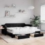 Ausziehbares, schwarzes Tagesbett mit Schubladen (80x200 cm) im Wohnzimmer.