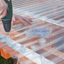 Montage einer transparenten Acryl-Trapezplatte als Kunststoffbedachung mit Schrauben.