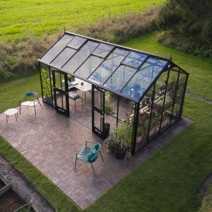 Schwarzes Juliana Gewächshaus Jubii 60-15 mit Doppeltür und Glasfront im Garten.