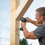 Mann schraubt mit dem Bosch 18V Akku-Bohrschrauber Advanced Drill 18 V-80 ein Holzkonstrukt zusammen.