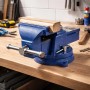 Blauer Wiltec Schraubstock Light Duty mit 150mm Klemmbacken und Amboss auf Werkbank. Spannt Holzstück. Präzise Fixierung.