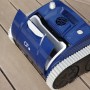 CF Poolroboter CF200CL, blau-schwarz, mit geöffnetem Filterfach auf Holzdeck.