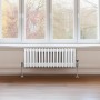 Weißer 3-Säulen Heizkörper (300x832 mm) im traditionellen Design vor Fenster montiert.