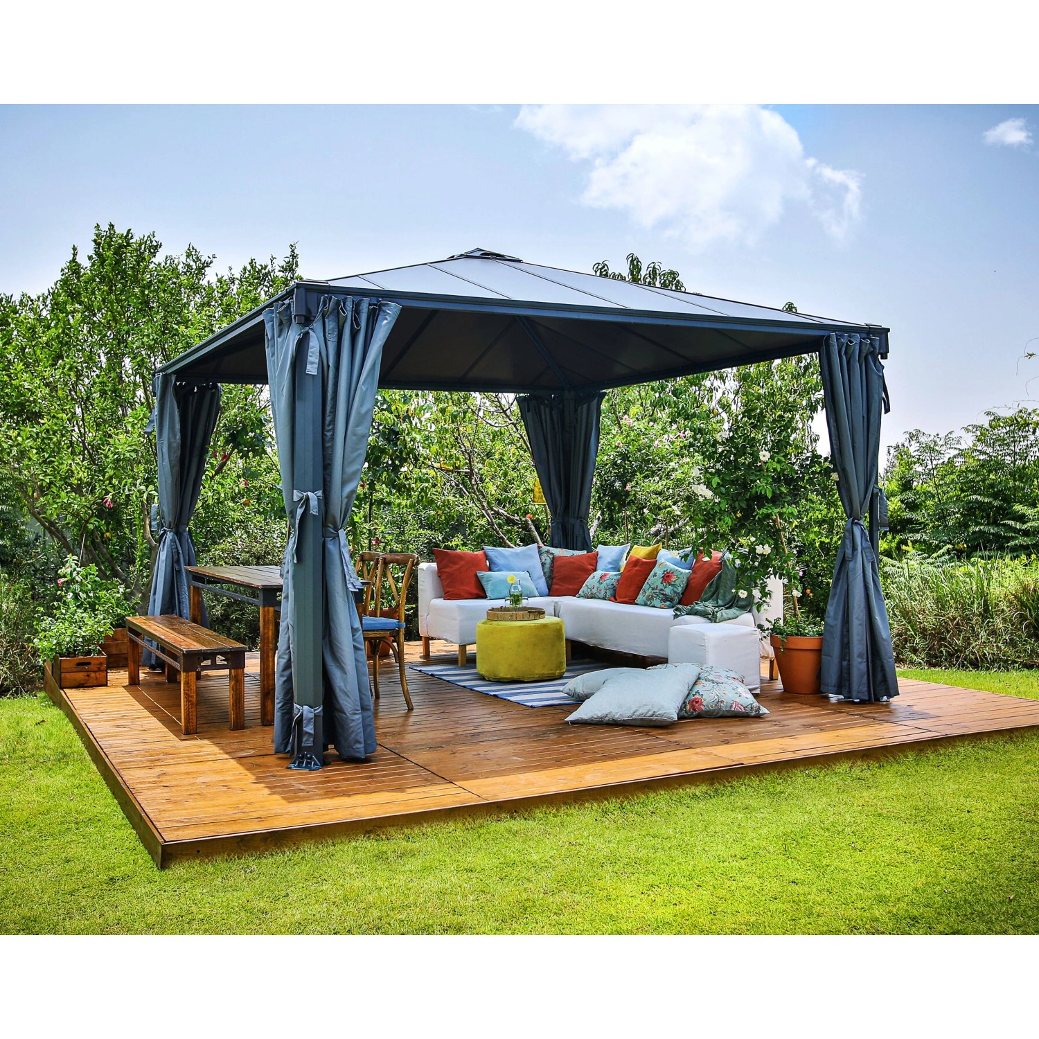 Canopia Gartenpavillon Palermo 3.6 x 3.6 Anthrazit mit Vorhängen und Gartenmöbeln auf Holzterrasse.