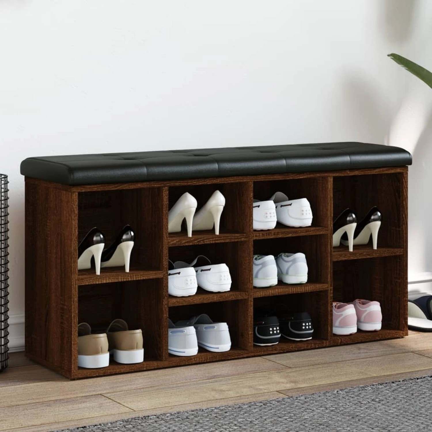 Schuhbank in Eichenoptik mit schwarzem Sitzkissen und mehreren Schuhfächern.