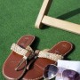 Hellgrauer Primaflor Rasenteppich Comfort mit Schuhen und Sonnenbrille im Garten.