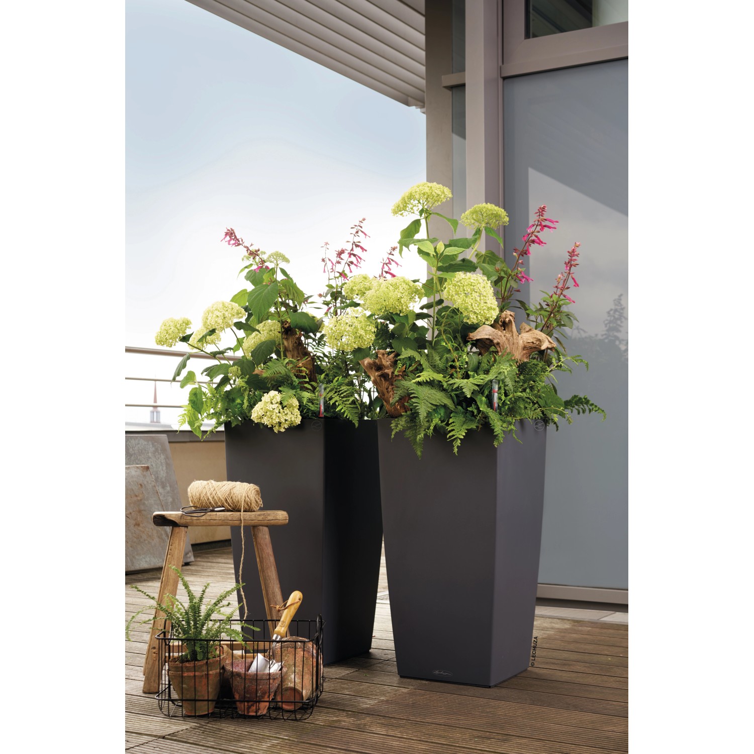 Lechuza Cubico Color 30 Pflanzsäule in Schiefergrau, bepflanzt mit Blumen und Pflanzen.