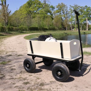 Schwarzer Sunny Bollerwagen Billy Beach Wagon mit Luftreifen vor See und Bäumen.