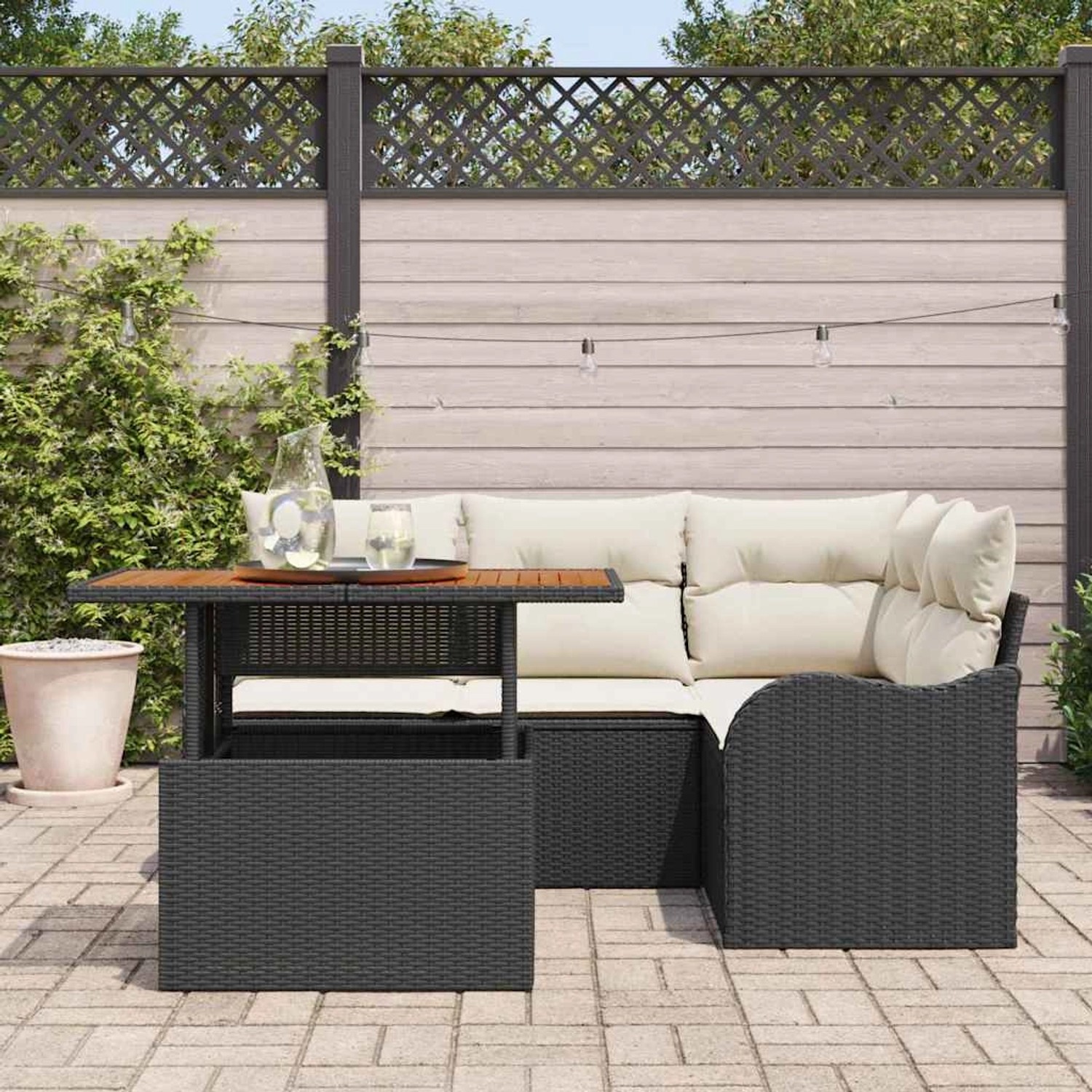 Schwarzes 5-teiliges Gartensofa Set aus Poly Rattan mit Tisch und Kissen.