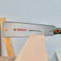 Bosch Japansäge Ryoba 250 mm beim Sägen von Holz. Zugsäge mit doppelseitigem Sägeblatt.