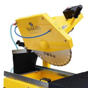 Gelbe BAMATO Steintrennmaschine mit großer Diamantscheibe und blauer Wasserkühlung für präzise Steinschnitte.