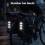 Wiltec Doppeltasche am Fahrrad-Gepäckträger bei Regen. Reflektierende Pfeile sorgen für Sichtbarkeit in der Nacht.