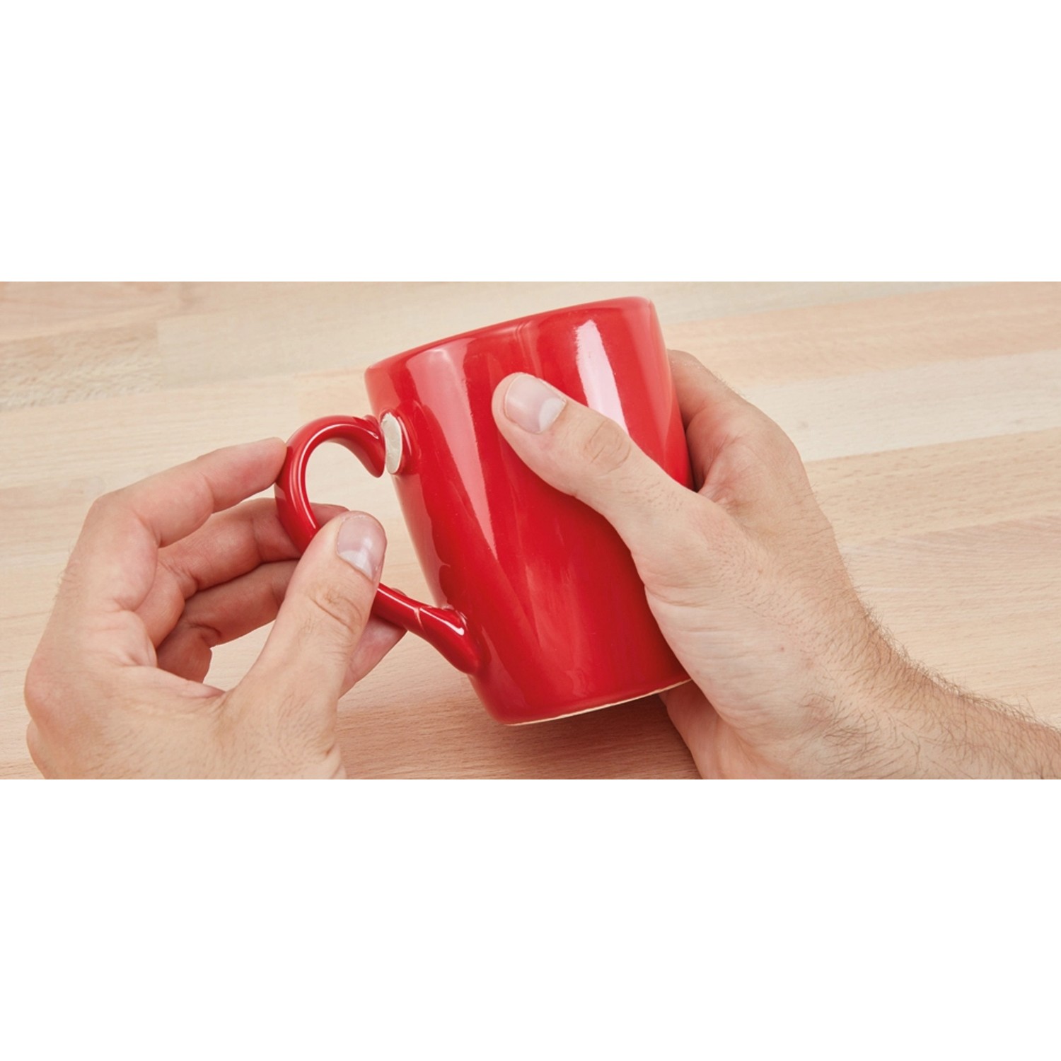 Fischer 30 Sekunden Kleber 15g: Hände kleben roten Becher auf Holzuntergrund.